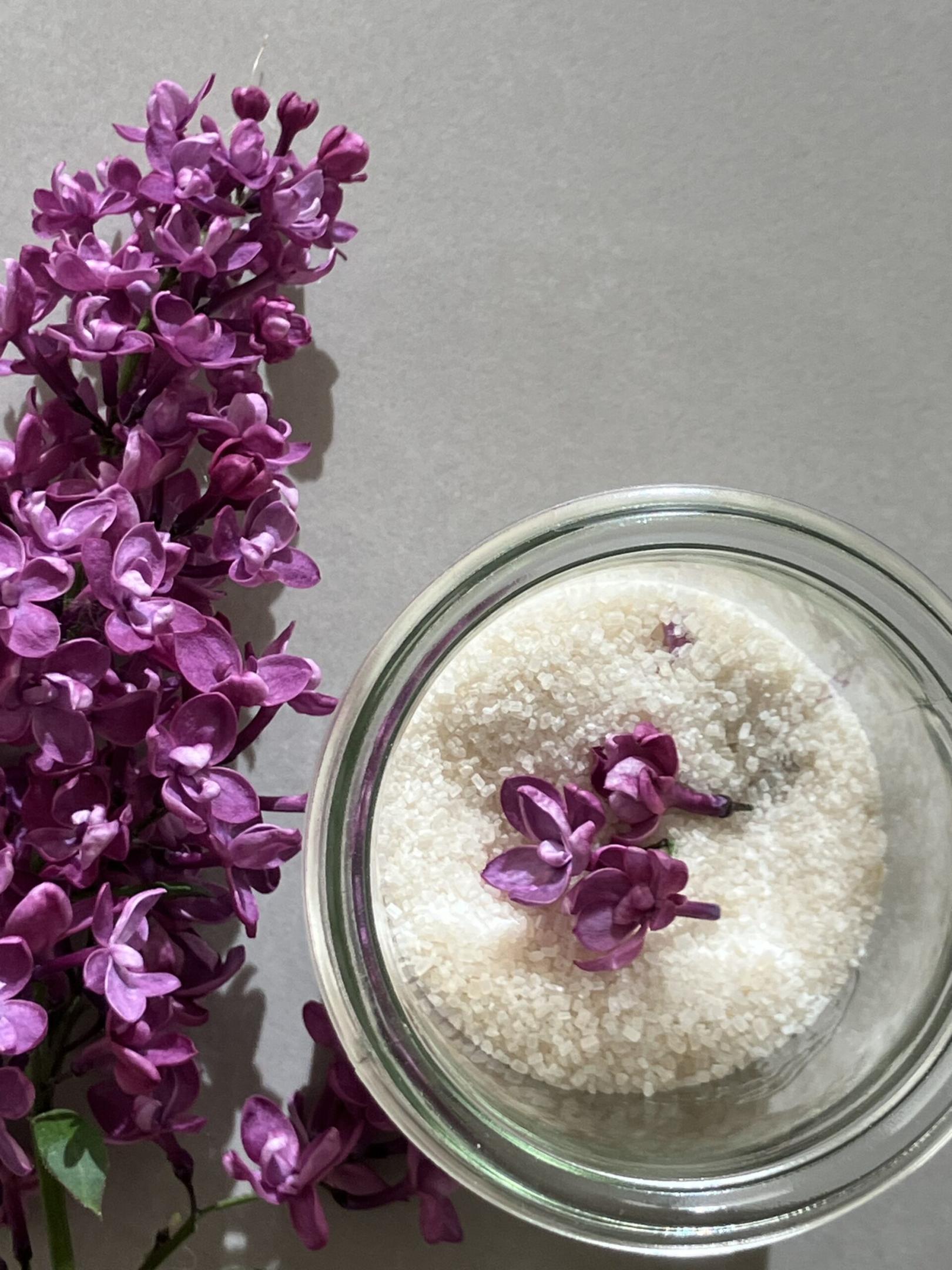 Un peu de sucre blond, infusé aux fleurs de lilas, posé sur une table de cuisine.