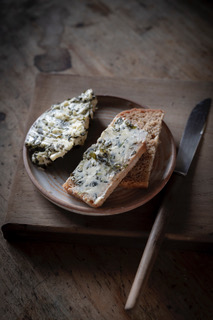 Une assiette avec des tranches de pain tartinées de beurre aux algues et aux herbes.